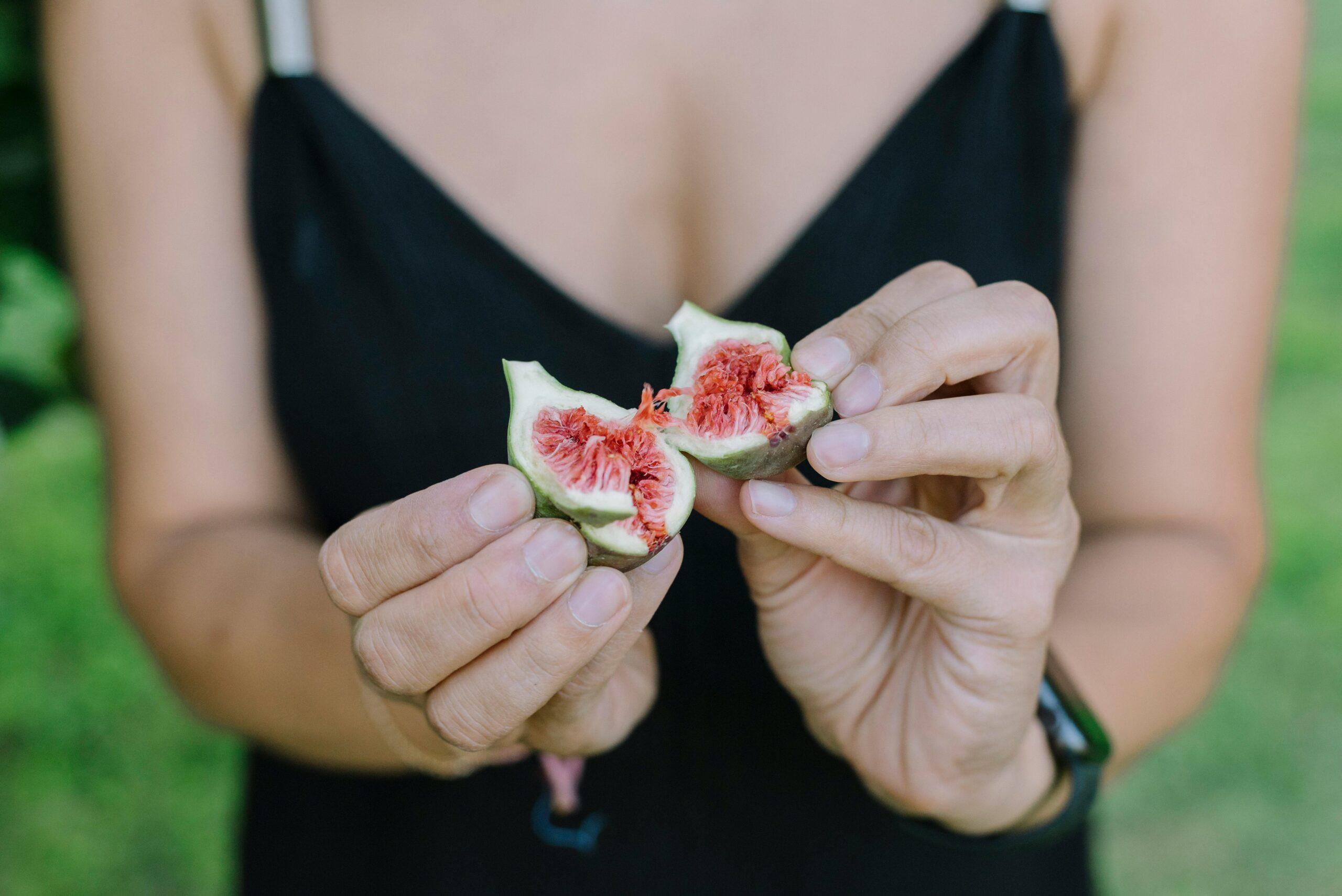 Close-up of Woman Holding Fresh Fig Outdoors